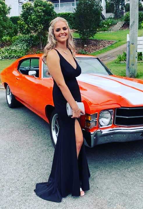 beautiful girl wearing a black formal dress in front of red GT