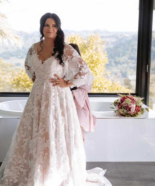 Beautiful bride wearing a lace wedding gown with lace sleeves